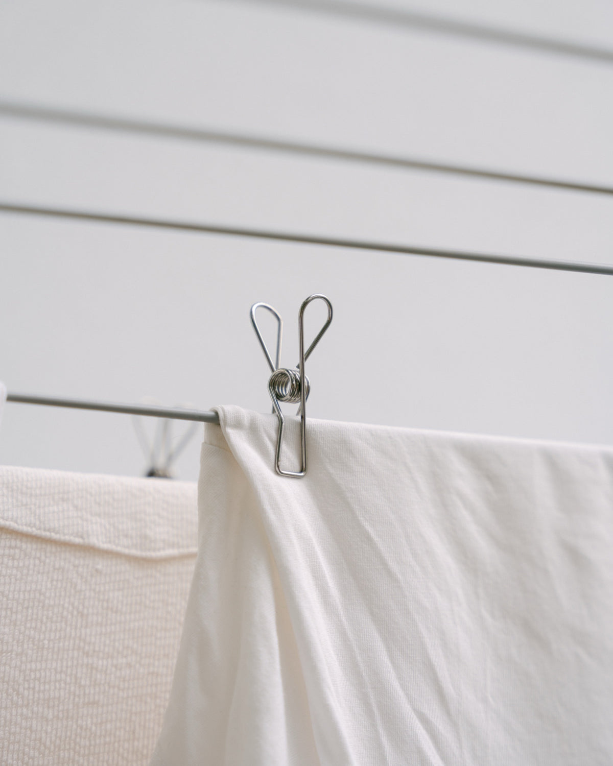 Forever Pegs marine-grade stainless steel peg holding a white sheet on a clothesline