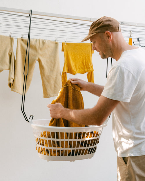 Gav, Hang Easy founder, hanging washing from a basket held at waist height by Hang Easy Basket Hangers