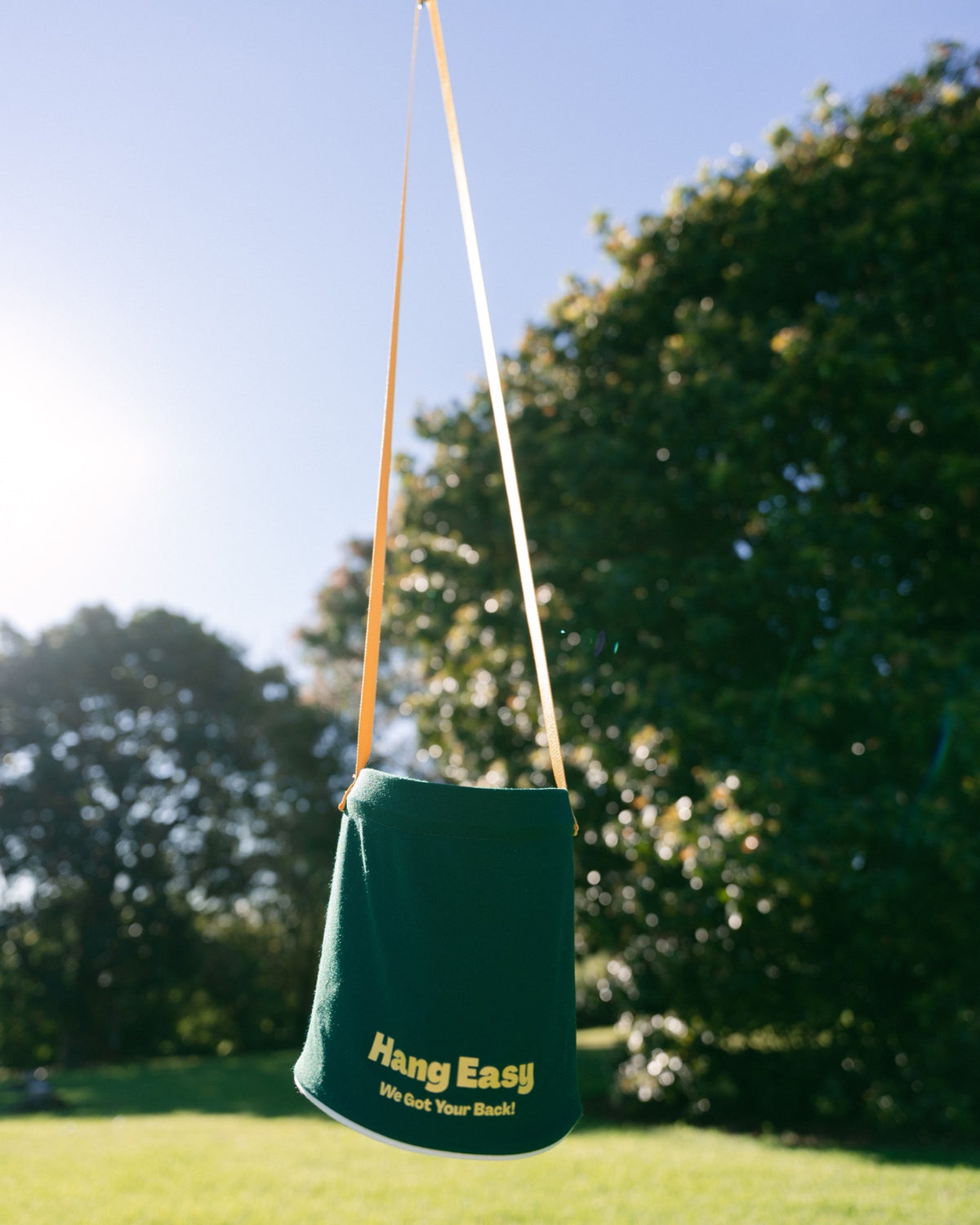 Hang Easy Peg Bag hanging from a rotary clothesline in a green backyard