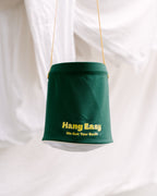 Green Hang Easy Peg Bag hanging in front of fresh white sheets on the clothesline