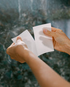 Tearing a The Good Stuff laundry sheet in half for a standard wash
