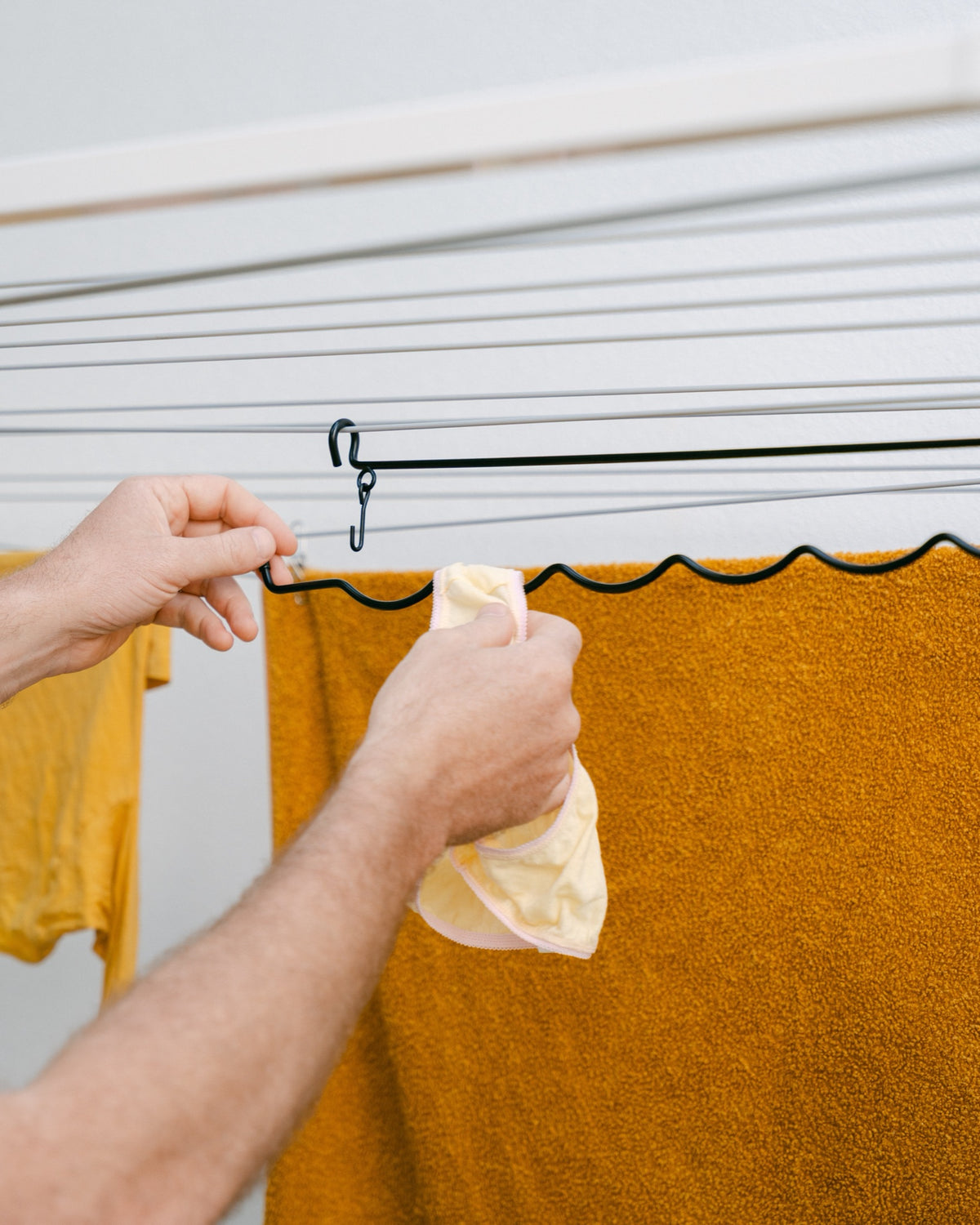 The Undie Hanger hooked over a towel on the clothesline